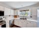 Bright kitchen with white cabinets, stainless steel appliances, and a window providing natural light at 5016 Silhouette Dr, Durham, NC 27713