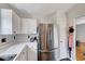Bright kitchen featuring white cabinets, sleek countertops, and a stainless steel refrigerator at 5016 Silhouette Dr, Durham, NC 27713