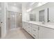 Bathroom featuring double sinks, sleek white cabinets, and a glass-enclosed shower at 502 Gainer Dr # 2, Raleigh, NC 27610