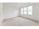 Bright bedroom with neutral carpet, white walls, and large windows for ample natural light at 502 Gainer Dr # 2, Raleigh, NC 27610