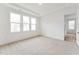 Neutral carpeted bedroom with white walls, ample natural light, and a walk-in closet at 502 Gainer Dr # 2, Raleigh, NC 27610