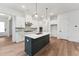 Modern kitchen featuring white cabinets, gray backsplash, and island with a dark gray base at 502 Gainer Dr # 2, Raleigh, NC 27610