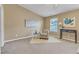 Calm bedroom featuring neutral walls, carpet, an accent chair, and ample natural light at 5110 Neuse Commons Ln # 109, Raleigh, NC 27616