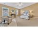 Large primary bedroom with a ceiling fan, stylish chair, and large windows at 5110 Neuse Commons Ln # 109, Raleigh, NC 27616