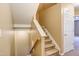 Carpeted stairs with white risers and a wooden handrail at 5110 Neuse Commons Ln # 109, Raleigh, NC 27616