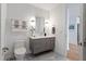 Modern bathroom with gray cabinets, white counter, toilet, and decorative towels at 523 S West St # 404, Raleigh, NC 27601