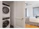 Modern white stackable washer and dryer tucked behind a sleek, white door near the primary bedroom at 523 S West St # 404, Raleigh, NC 27601