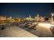 Stunning night view from roof deck with modern outdoor seating and illuminated cityscape as a backdrop at 523 S West St # 404, Raleigh, NC 27601