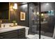 Stylish bathroom with dark walls, modern fixtures, and a glass-enclosed shower at 5312 Woodsdale Rd, Raleigh, NC 27606