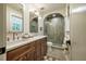 Bathroom with double sink vanity, an arched shower with tile surround, and neutral tile floors at 5312 Woodsdale Rd, Raleigh, NC 27606