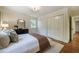 Bedroom featuring hardwood floors, white walls, three closets and a black dresser at 5312 Woodsdale Rd, Raleigh, NC 27606