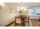 Bright dining room showcases a wooden table, decorative lighting, and wainscoting at 5312 Woodsdale Rd, Raleigh, NC 27606