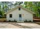 Charming white brick home with a light blue front door and well-manicured landscaping at 5312 Woodsdale Rd, Raleigh, NC 27606