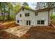 View of the back of the home, featuring a white brick exterior, walkout basement, and multiple windows at 5312 Woodsdale Rd, Raleigh, NC 27606