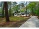 Wide view of a lovely white brick home with a well-manicured lawn and mature trees at 5312 Woodsdale Rd, Raleigh, NC 27606
