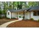 Charming single-story white brick home with copper gutters, blue door, and manicured landscaping at 5312 Woodsdale Rd, Raleigh, NC 27606