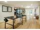 Bright basement featuring a ping pong table, living area, and backyard access at 5312 Woodsdale Rd, Raleigh, NC 27606