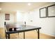 Ping pong table set up in the basement ready for a game, with minimalist decor at 5312 Woodsdale Rd, Raleigh, NC 27606