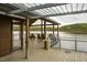 People relax on rocking chairs under a covered area with a beautiful view of the lake at 5312 Woodsdale Rd, Raleigh, NC 27606