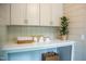This laundry area features custom cabinets, ample counter space and is decorated with plant at 5312 Woodsdale Rd, Raleigh, NC 27606