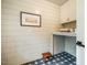 Bright laundry room features shiplap walls, custom cabinetry and floral patterned tile flooring at 5312 Woodsdale Rd, Raleigh, NC 27606
