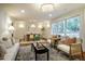 Bright and stylish living room with an open layout to the dining area, classic white trim, and hardwood floors at 5312 Woodsdale Rd, Raleigh, NC 27606