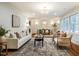 Bright and stylish living room with an open layout to the dining area, classic white trim, and hardwood floors at 5312 Woodsdale Rd, Raleigh, NC 27606