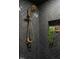 Close-up of a shower with dark chevron tiles, gold fixtures, and a niche at 5312 Woodsdale Rd, Raleigh, NC 27606