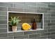 Close up of tiled niche in shower with decorative plant and soaps at 5312 Woodsdale Rd, Raleigh, NC 27606