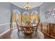 Elegant dining room with a round table, six chairs, and large windows with natural light at 5408 Colonial Oaks Dr, Apex, NC 27539