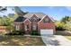 Beautiful brick home with a well-manicured lawn and a two-car garage and arched entryway at 5408 Colonial Oaks Dr, Apex, NC 27539