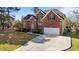 Beautiful brick home with a well-manicured lawn, driveway, two car garage and arched entryway at 5408 Colonial Oaks Dr, Apex, NC 27539