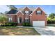 Traditional red brick two-story home with a well-manicured lawn and a two-car garage at 5408 Colonial Oaks Dr, Apex, NC 27539