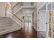 Grand foyer featuring hardwood floors, a staircase, and natural light streaming through a nearby window at 5408 Colonial Oaks Dr, Apex, NC 27539