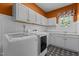Well-lit laundry room featuring modern machines, white cabinetry and sleek countertops for easy chore management at 5408 Colonial Oaks Dr, Apex, NC 27539