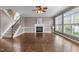 Cozy living room showcasing hardwood floors, a fireplace, staircase, and large windows for natural light at 5408 Colonial Oaks Dr, Apex, NC 27539