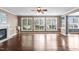 Spacious living room featuring hardwood floors, fireplace, and large windows overlooking the backyard at 5408 Colonial Oaks Dr, Apex, NC 27539