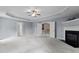 Bright main bedroom featuring a tray ceiling, fireplace, carpet, and access to other areas of the home at 5408 Colonial Oaks Dr, Apex, NC 27539