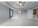Inviting main bedroom boasts a tray ceiling, ceiling fan, carpet, and access to an adjoining bathroom at 5408 Colonial Oaks Dr, Apex, NC 27539