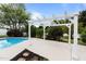 Backyard pool with a concrete patio and a pergola, surrounded by beautiful landscaping and privacy at 5408 Colonial Oaks Dr, Apex, NC 27539