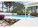 Backyard pool with surrounding white fencing, beautiful landscaping, and a concrete patio with a pergola at 5408 Colonial Oaks Dr, Apex, NC 27539