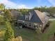 Aerial view of the home's backyard featuring a patio set, grill, and screened-in porch, surrounded by lush green grass at 5733 Mizuno Dr, Fuquay Varina, NC 27526