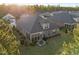 Aerial shot of the house showcasing the backyard, patio set, grill, and the screened-in porch with the sun shining at 5733 Mizuno Dr, Fuquay Varina, NC 27526