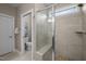 Modern bathroom featuring a tiled shower with a glass door, bench, and pebble flooring accent at 5733 Mizuno Dr, Fuquay Varina, NC 27526