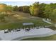 Aerial view of a modern golf driving range with covered bays and adjacent putting greens at 5733 Mizuno Dr, Fuquay Varina, NC 27526