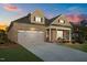 Beautiful exterior of a brick home boasting a two-car garage and covered front porch at dusk at 5733 Mizuno Dr, Fuquay Varina, NC 27526