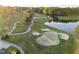 Aerial view of golf course showcasing a green, sand traps, and a scenic lake backdrop at 5733 Mizuno Dr, Fuquay Varina, NC 27526