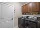 Laundry room features full size washer, dryer, and wooden cabinets for ample storage at 5733 Mizuno Dr, Fuquay Varina, NC 27526