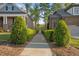 Brick homes flank a walkway leading towards a serene view of a lake surrounded by lush trees at 5733 Mizuno Dr, Fuquay Varina, NC 27526