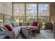 Inviting sunroom with comfortable seating, a ceiling fan, and large windows showcasing the surrounding greenery at 5733 Mizuno Dr, Fuquay Varina, NC 27526